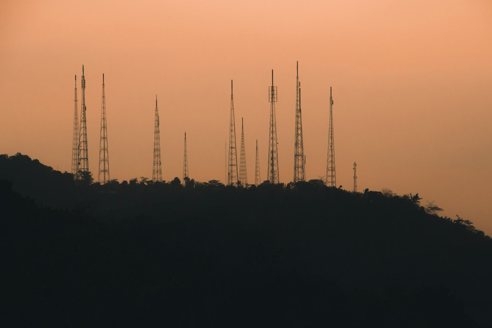 Antennes de télécommunication sur une colline au coucher du soleil