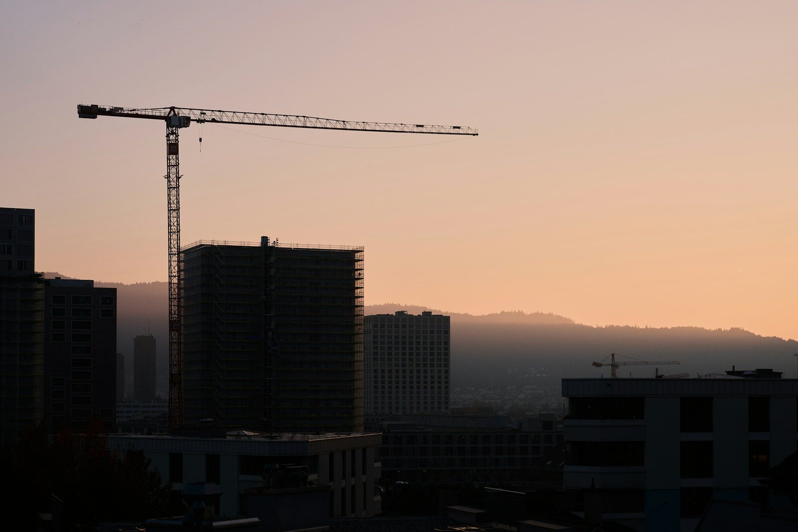 Grue de chantier et immeubles en construction au coucher du soleil